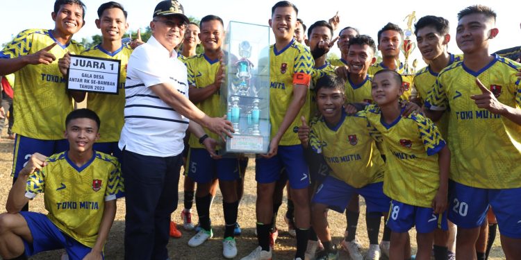 SAKSIKAN LAGA FINAL TURNAMEN SEPAK BOLA GALA DESA BAMBAN, BUPATI HSS SERAHKAN PIALA DAN UANG PEMBINAAN BAGI JUARA TURNAMEN