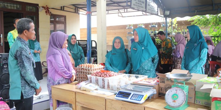 PJ. KETUA TP. PKK KAB. HSS DAN WAKIL KETUA I TP. PKK PANTAU GELAR PANGAN MURAH TTI DI DESA TELUK HAUR